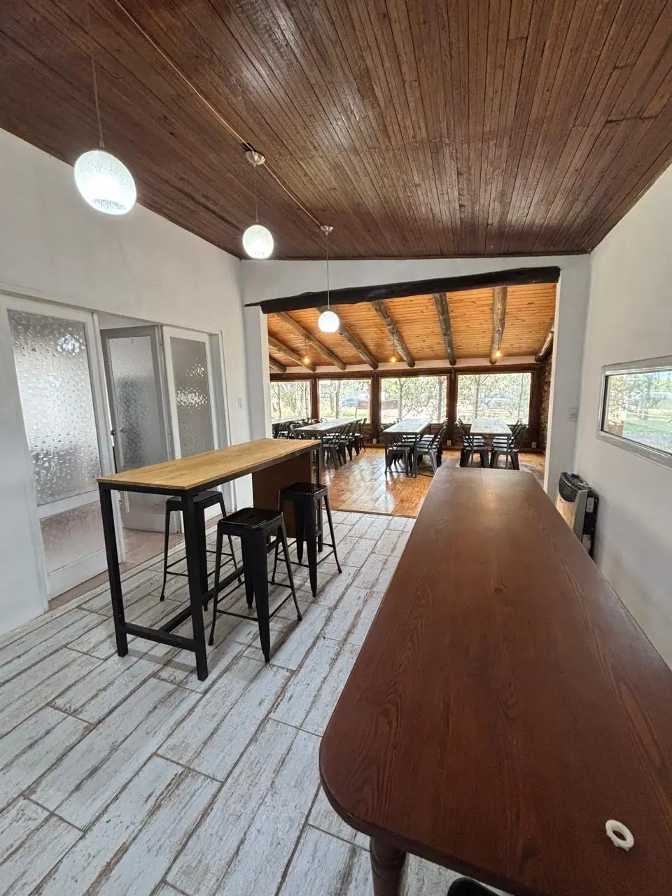 Salón con barra alta, banquetas y mesas · La Casona de Bahía