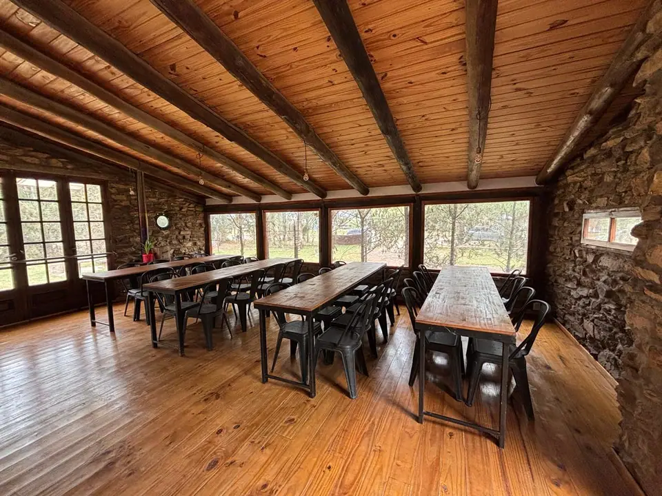 Quincho con mesas largas y techo de madera · La Casona de Bahía