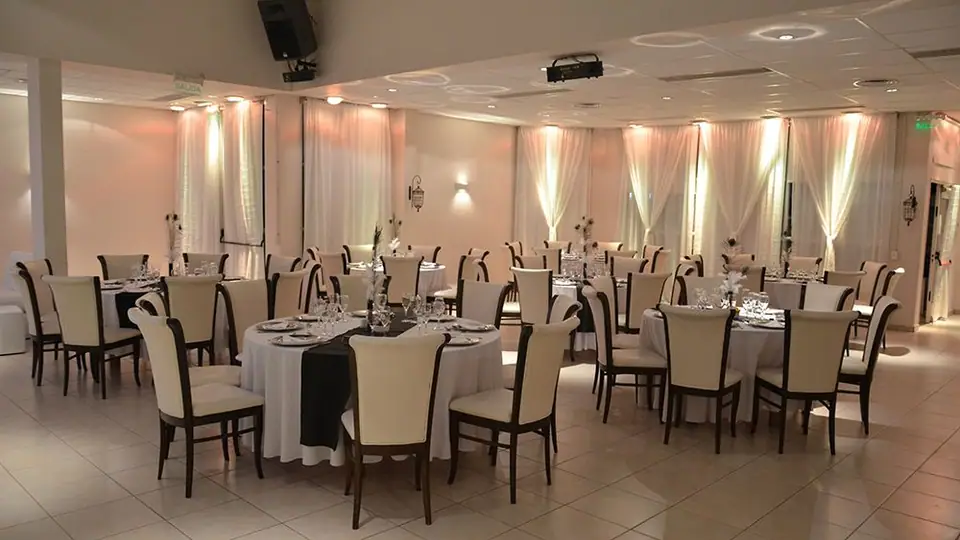 Salón con mesas redondas y sillas tapizadas · Revoque Eventos