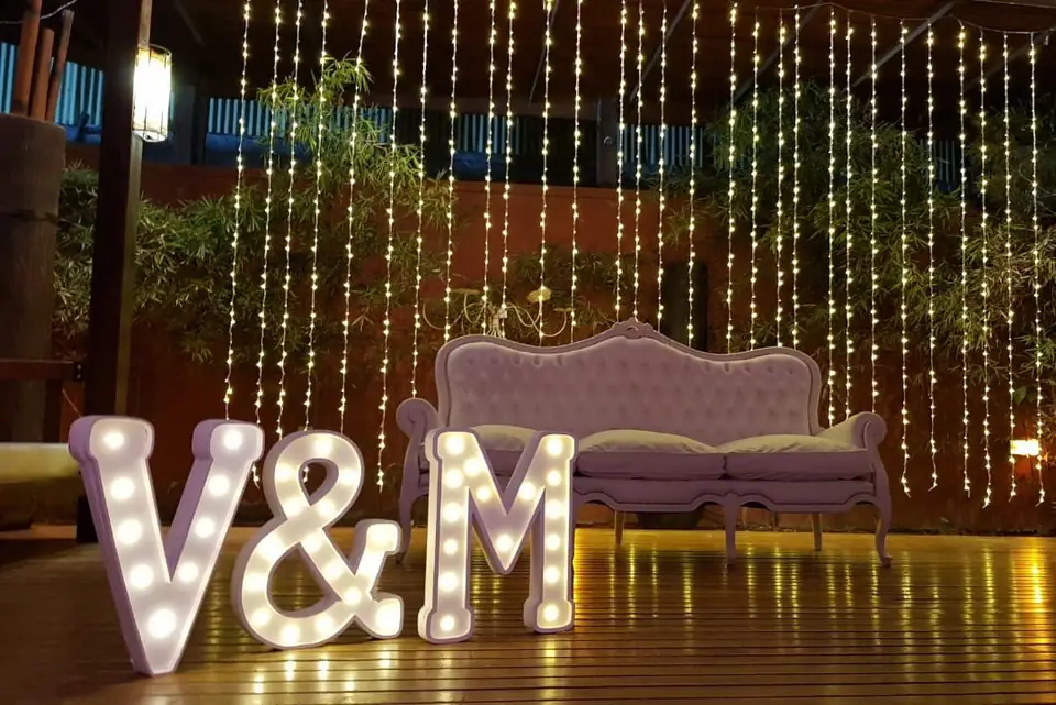 Living exterior con luces y letras iluminadas · Revoque Eventos