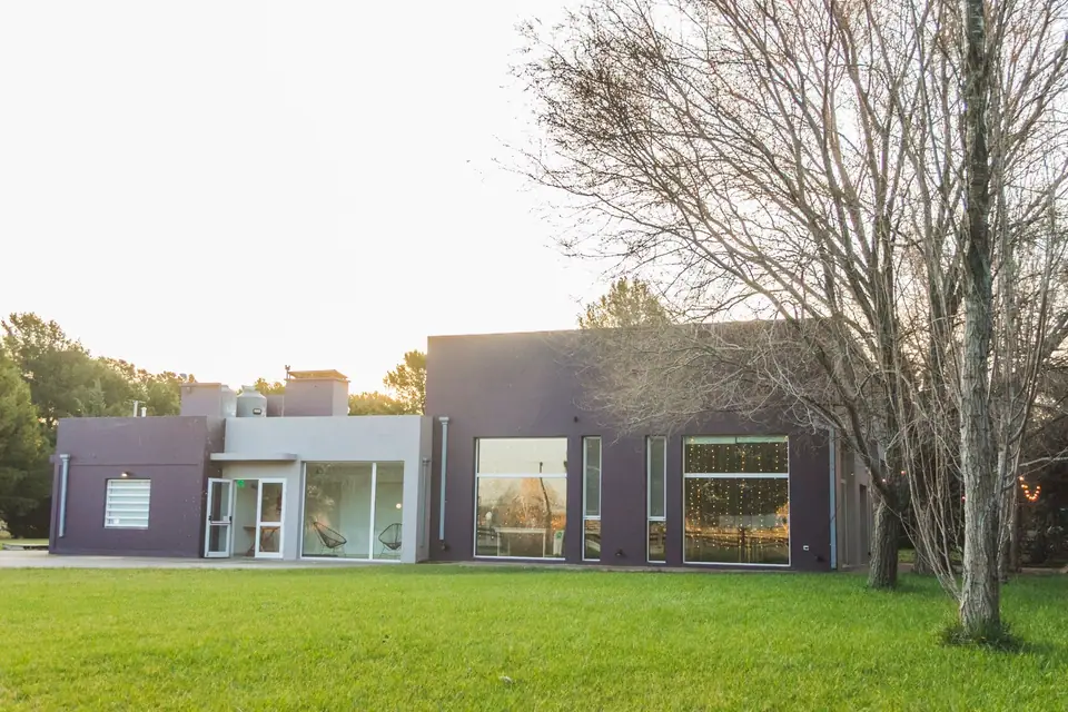 Salón moderno con ventanales y parque · LOT Eventos